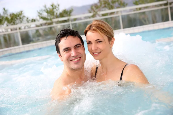 Couple enjoying jacuzzi in spa center — Stock Photo, Image