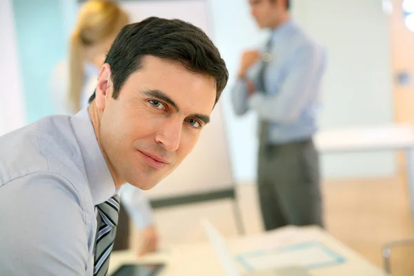 Selbstbewusster Geschäftsmann stützt sich auf den Tisch — Stockfoto