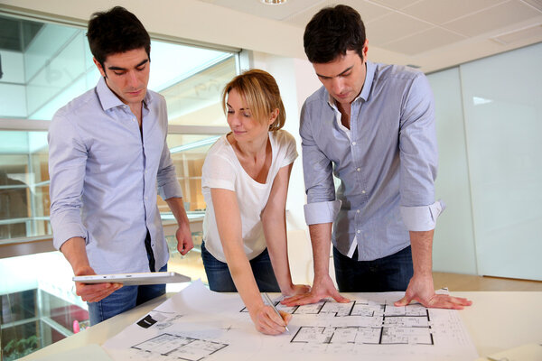 Группа архитекторов, работающих в офисе
