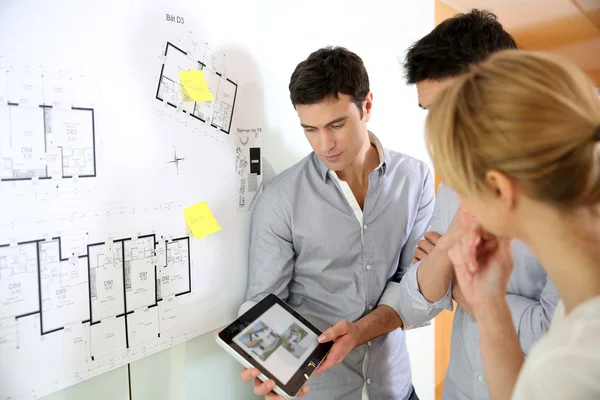 Architects in office looking at construction project — Stock Photo, Image