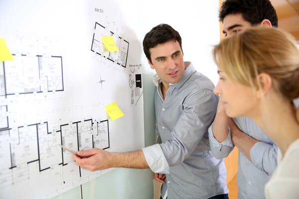 Архитекторы в офисе рассматривают проект строительства
