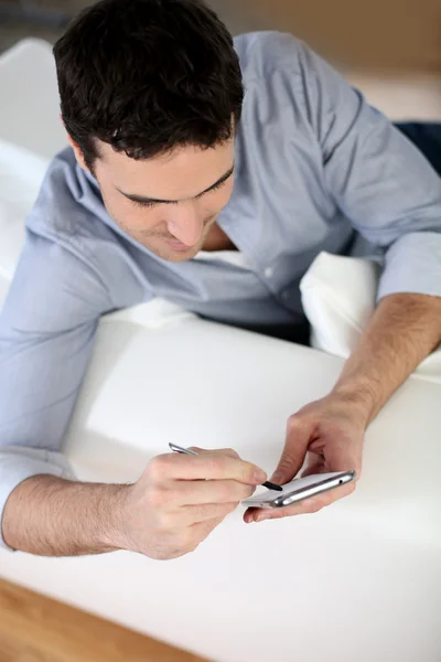 Upper view of man in sofa using smartphone — Stock Photo, Image
