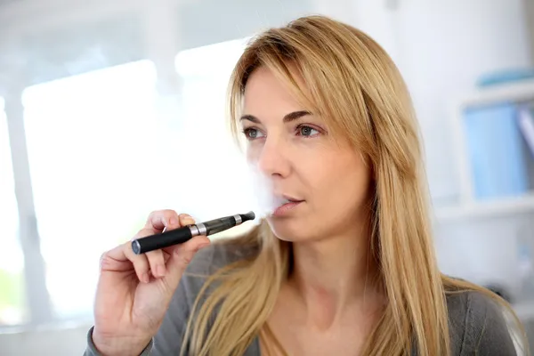 Femme fumant avec cigarette électronique — Photo