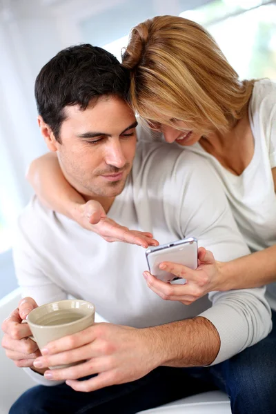 Donna allegra mostrando smartphone al fidanzato — Foto Stock