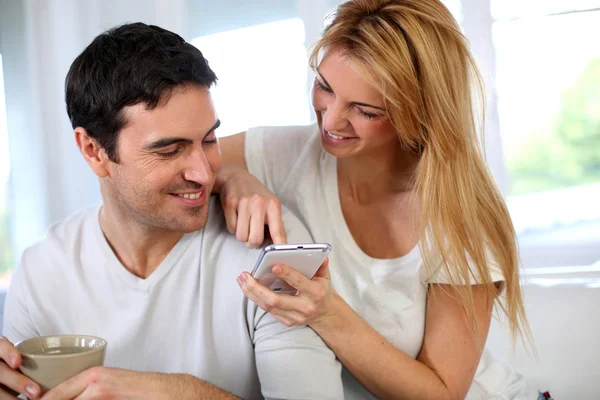 Cheerful woman showing smartphone to boyfriend — Stock Photo, Image