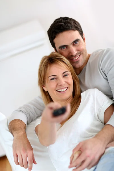 Söt par i soffan tittar på tv — Stockfoto
