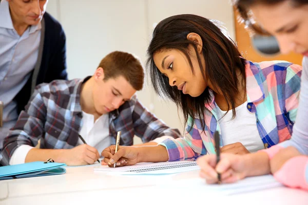 Gruppe von Teenagern in der Klasse schreibt eine Prüfung — Stockfoto