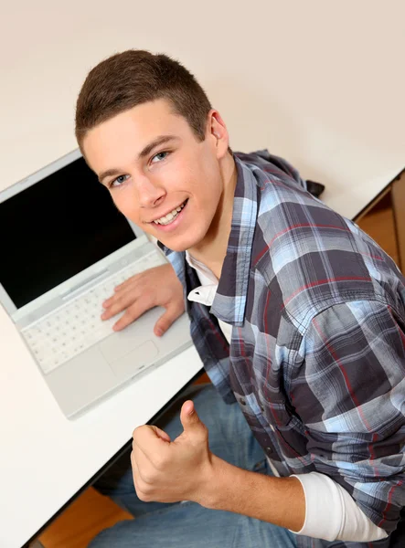 Studente con computer portatile mostrando pollice in su — Foto Stock