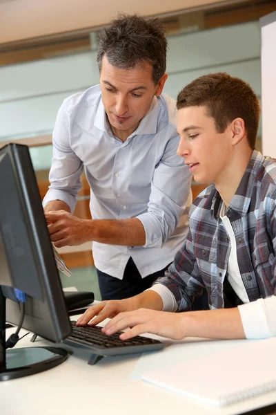 Erwachsener Mann hilft Schülerin im Klassenzimmer — Stockfoto