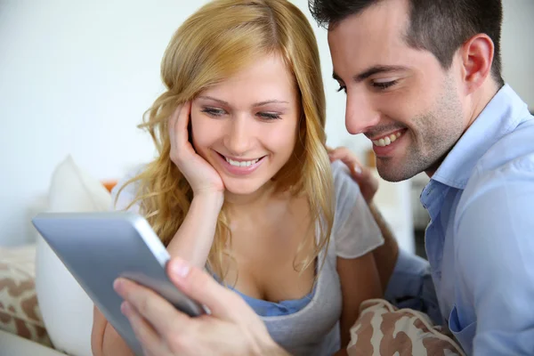 Cheerful couple websurfing with digital tablet at home — Stock Photo, Image