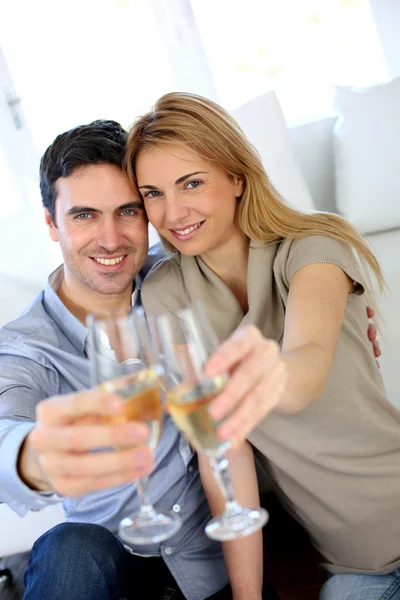 Par hålla glas champagne mot kameran Stockbild