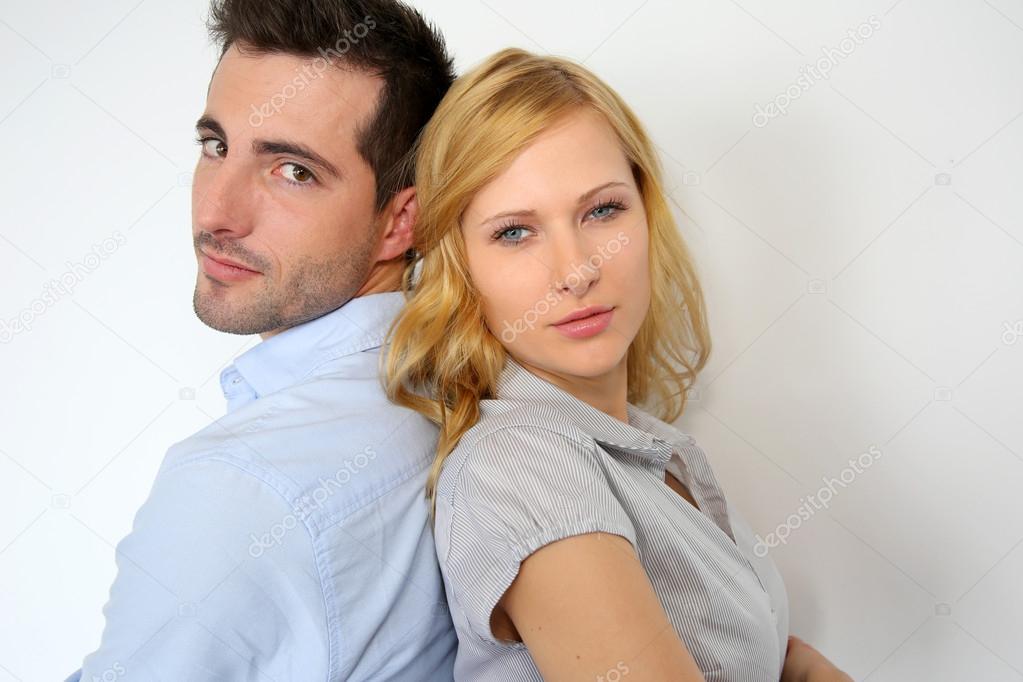 Couple standing back to back on white background
