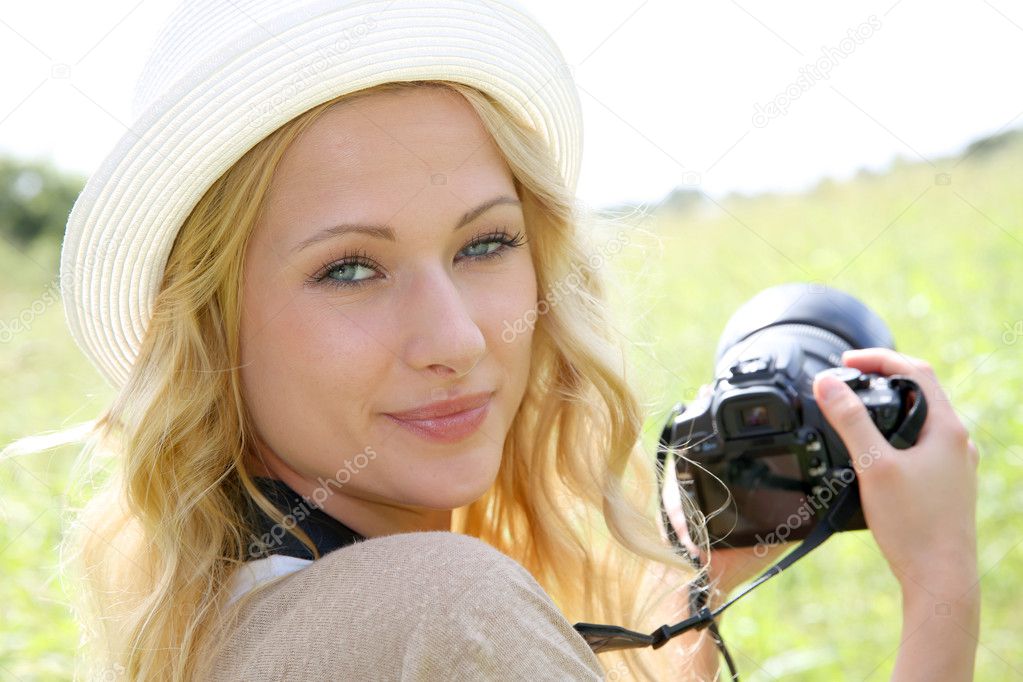 Portrait of adventure girl using photo camera in nature