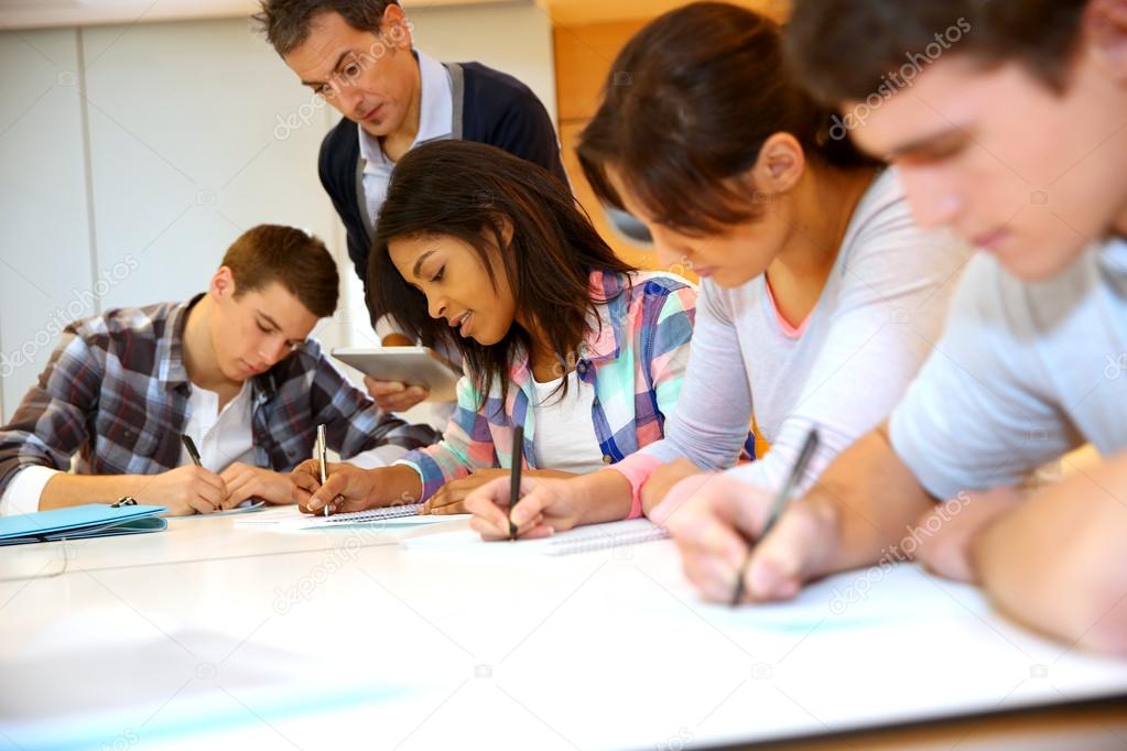 Group of teenagers in class writing an exam