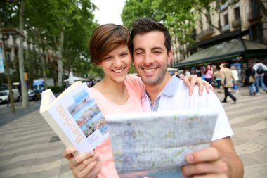 Couple looking at map in La Rambla de Barcelona clipart