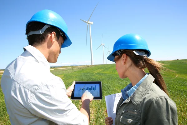 Ingenieros usando tableta en sitio de turbina eólica — Foto de Stock