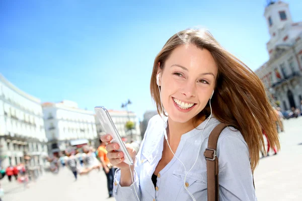 Chica alegre usando smartphone en la ciudad — Foto de Stock