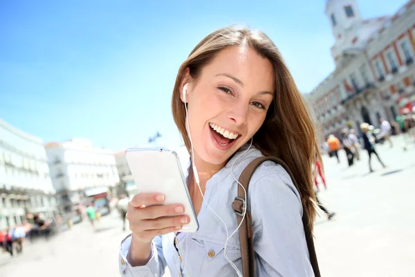 Vrolijk meisje met smartphone in de stad — Stockfoto