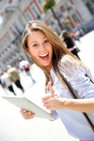 Veselá dívka s tablet ukazuje palec — Stock fotografie