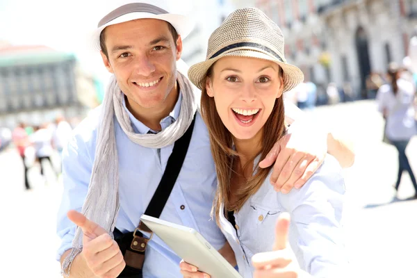 Pareja con tableta mostrando los pulgares hacia arriba — Foto de Stock