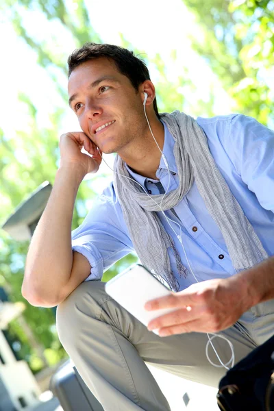 Handsome guy using smartphone and earphones — Stock Photo, Image