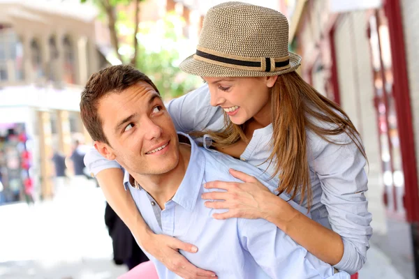 Man ger piggyback rida till flickvän i stan — Stockfoto