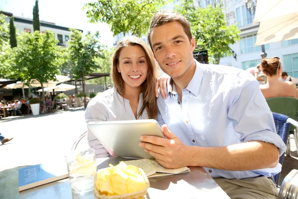 Casal conectado em tablet digital na Praça de Santa Ana — Fotografia de Stock