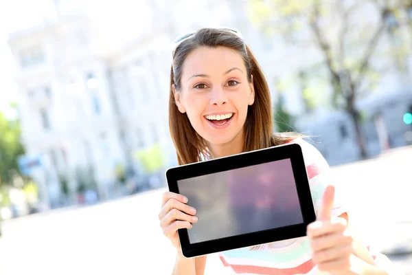 Fröhliches Mädchen in der Stadt zeigt Tablet-Bildschirm — Stockfoto