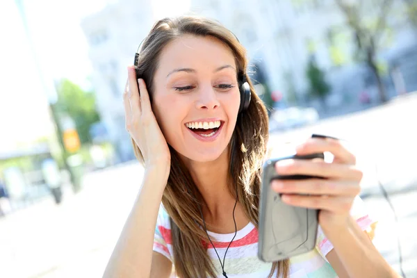Menina alegre ouvir música com smartphone — Fotografia de Stock