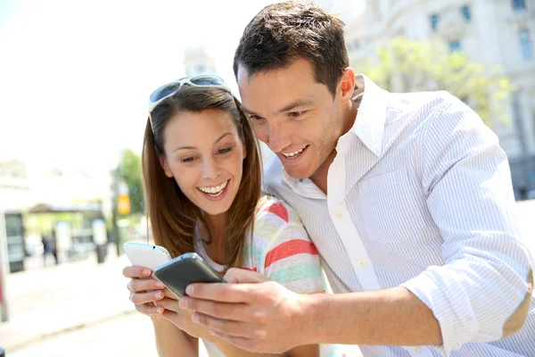 Par av turister i madrid med smartphone — Stockfoto