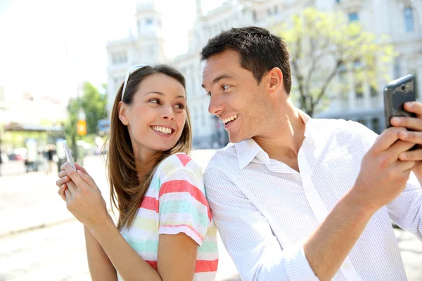 Couple of tourists in Madrid using smartphone — Stock Photo, Image