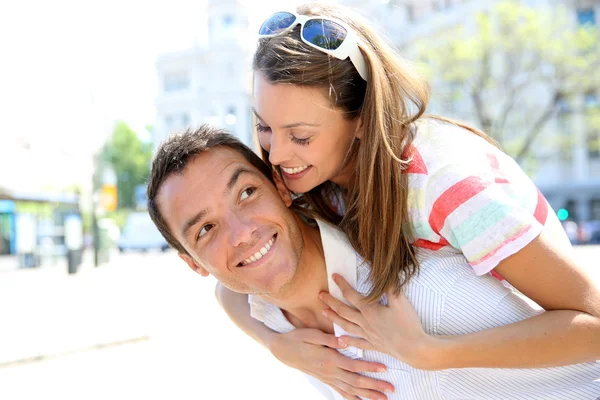 Hombre dando paseo a cuestas a su novia — Foto de Stock