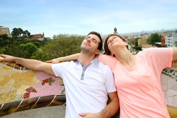 Couple de touristes se détendre sur le banc Guell Park — Photo