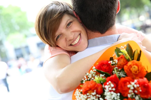 Portrait of cheerful girl holding bunch of flowers — Stock Photo, Image