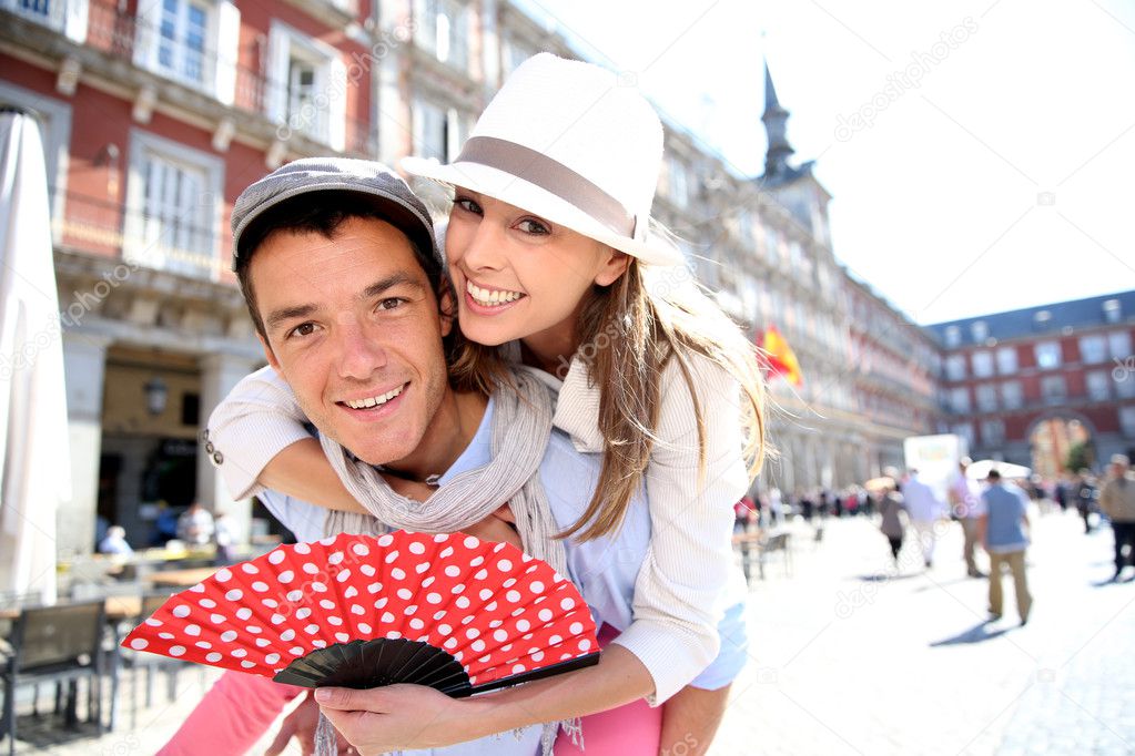 Man giving piggyback ride to girlfriend in Madrid