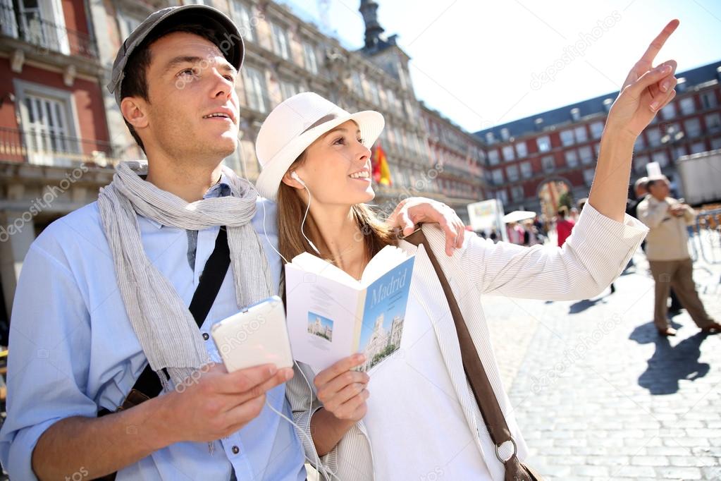 Tourists walking in La Plaza Mayor with traveler guide