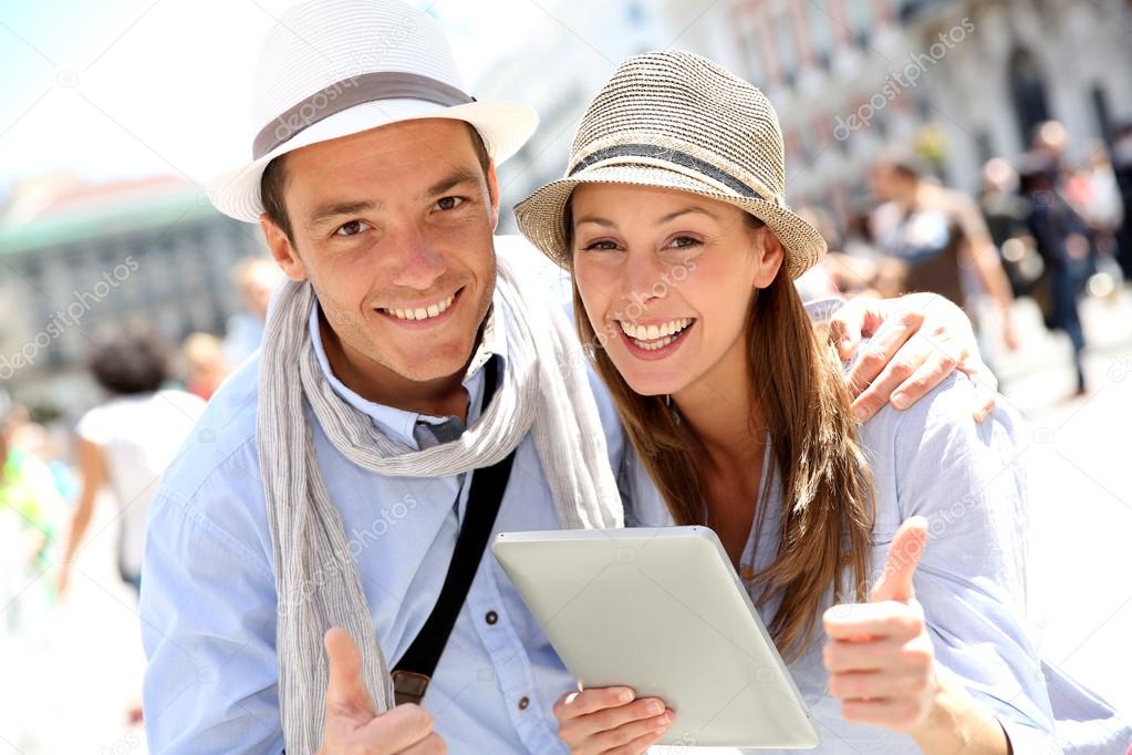Couple with tablet showing thumbs up