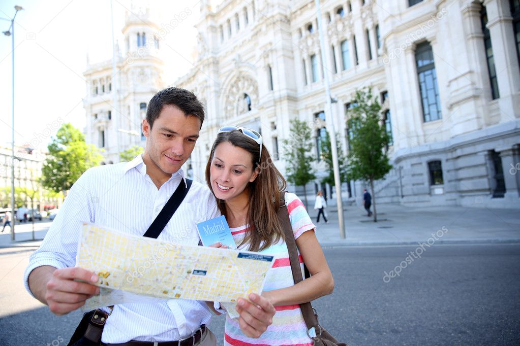 Tourists reading map in front of Palacio de Comunicaciones