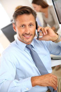 İş adamı cep telefonuyla konuşuyor.