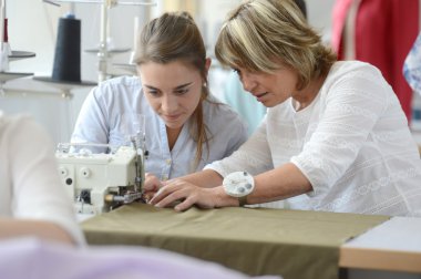 Student with teacher in dressmaking class clipart