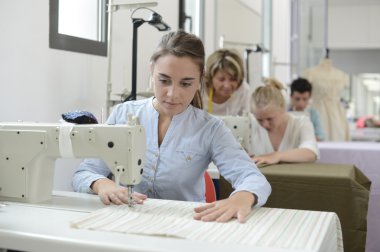 dikiş makinesi üzerinde çalışan eğitim sınıfında öğrenci kız