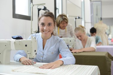 dikiş makinesi üzerinde çalışan eğitim sınıfında öğrenci kız