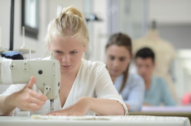 dikiş makinesi üzerinde çalışan eğitim sınıfında öğrenci kız