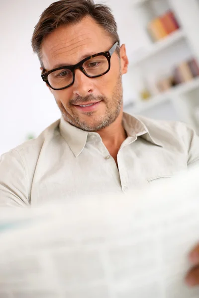 Mann mit Brille liest Zeitung — Stockfoto