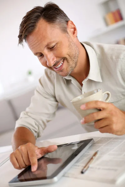 Hombre leyendo noticias en la tableta y beber café —  Fotos de Stock