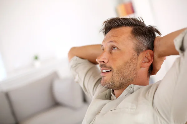 Man relaxing with outstretched arms behind head — Stock Photo, Image