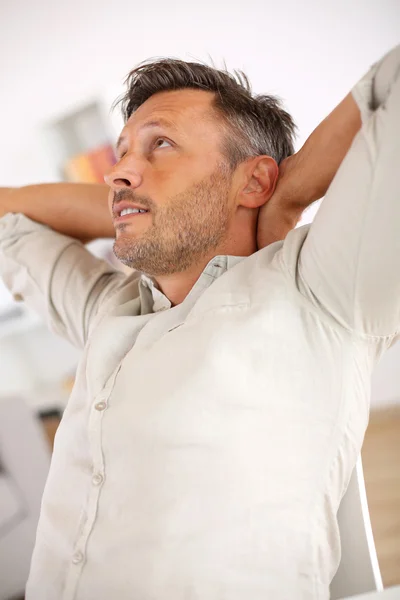 Homem relaxante com os braços estendidos atrás da cabeça — Fotografia de Stock