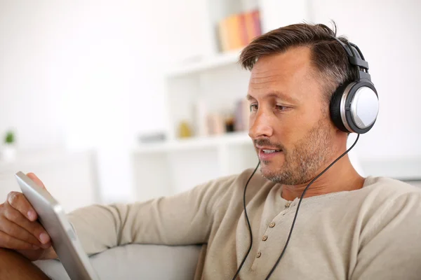 Uomo con tablet e cuffie — Foto Stock