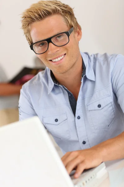 Lachende aantrekkelijke jonge man in office — Stockfoto
