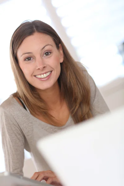 Bilgisayarda çalışan gülümseyen kadın. — Stok fotoğraf